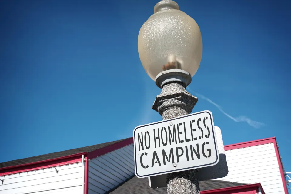 "No homeless camping" sign on a light post